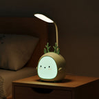 Lampe de bureau enfant Doudou allumée le soir sur une table de chevet, tête lumineuse et ventre veilleuse éclairés