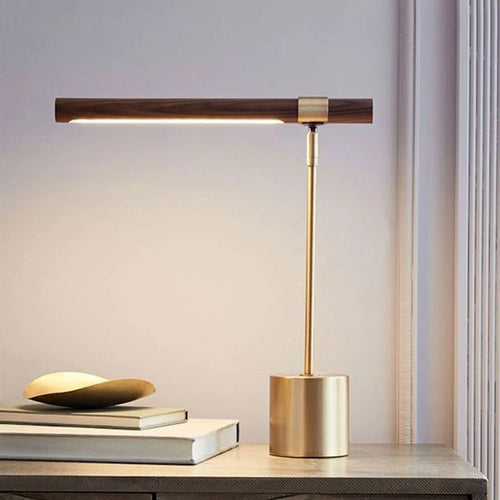Lampe de bureau design Linéa allumée sur une console, ambiance chaleureuse en fin de journée.