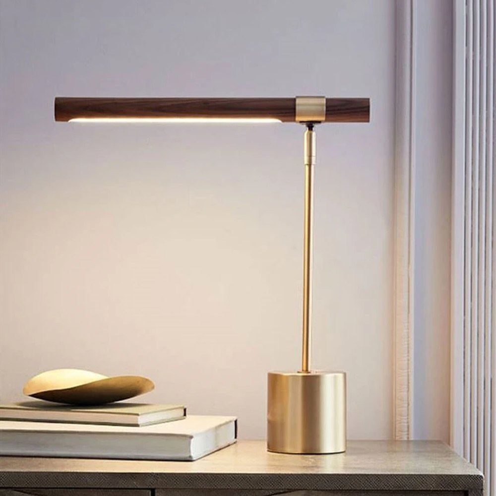 Lampe de bureau design Linéa allumée sur une console, ambiance chaleureuse en fin de journée.