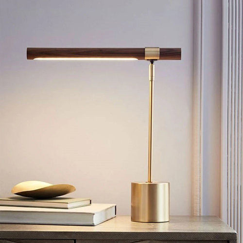 Lampe de bureau design Linéa allumée sur une console, ambiance chaleureuse en fin de journée.