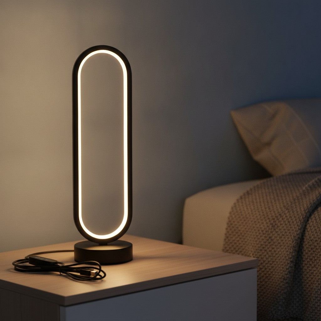 Lampe de bureau design Opale allumée le soir sur une table de chevet, anneau lumineux blanc chaud