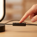 Main appuyant sur un bouton du boîtier de commande de la lampe Opale