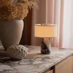 Lampe de bureau Vesta en marbre allumée sur un bureau, ambiance chaleureuse