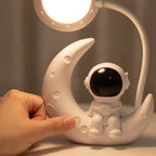 Main réglant l'intensité lumineuse de la veilleuse Astro Candeora depuis le socle en croissant de lune