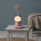 Lampe de bureau enfant Câlin rose, en veilleuse le soir sur une table de nuit