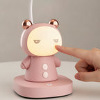 Main d'adulte qui touche la lampe de bureau enfant Câlin rose, face lumineuse allumée