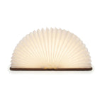 Lampe de bureau enfant Conte, livre en bois ouvert en éventail lumineux, finition noyer, sur fond blanc — Candeora