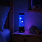 Veilleuse méduse Lagon allumée en bleu sur une table de chevet dans une chambre d'enfant la nuit