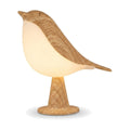 Lampe de bureau enfant Piou, veilleuse en forme d'oiseau à finition effet bois, allumée sur fond blanc — Candeora