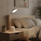 Lampe de bureau LED Andromède posée sur une table de nuit en journée
