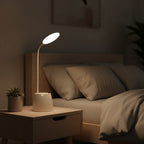 Lampe de bureau LED Andromède allumée le soir sur une table de nuit