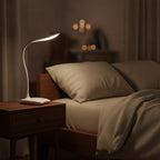 Lampe de bureau LED Cassiopée allumée le soir sur une table de chevet