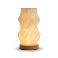 Lampe de bureau LED d'ambiance Halo, forme Vague ondulée, abat-jour imprimé en 3D et socle en bois, allumée sur fond blanc — Candeora