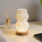 Lampe d'ambiance Halo allumée sur une table claire, à côté d'un diffuseur à bâtonnets — Candeora