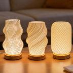 Les trois formes de la lampe d'ambiance Halo allumées côte à côte sur leurs socles en bois — Candeora