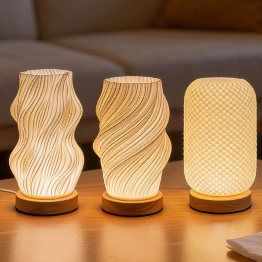 Les trois formes de la lampe d'ambiance Halo allumées côte à côte sur leurs socles en bois — Candeora