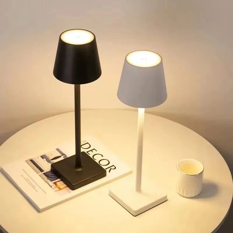 Les deux finitions de la lampe de bureau sans fil Alizé Candeora, noire et blanche, allumées sur une table