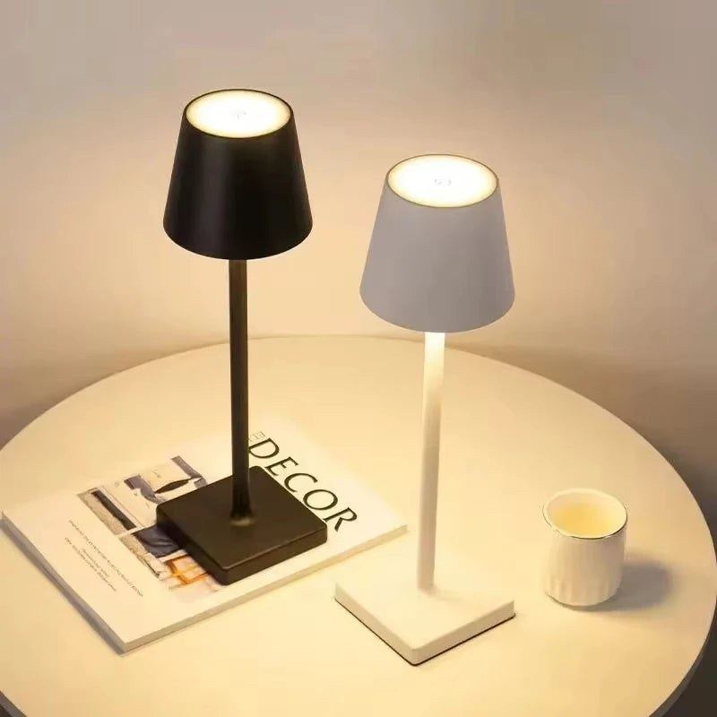 Les deux finitions de la lampe de bureau sans fil Alizé Candeora, noire et blanche, allumées sur une table