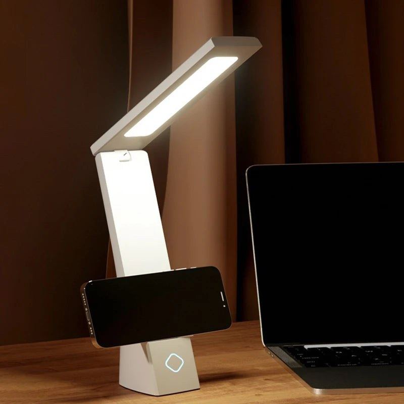 Téléphone posé dans le pli de la lampe de bureau Brise Candeora, qui lui sert de support