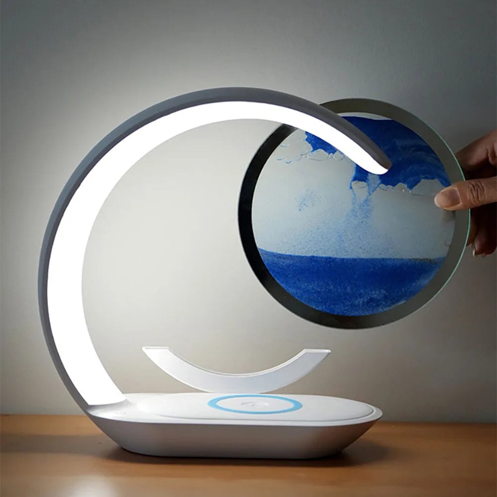 Main faisant pivoter le disque de sable de la lampe de bureau sans fil Sirocco Candeora