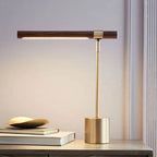 Lampe de bureau design Linéa allumée sur une console, ambiance chaleureuse en fin de journée.