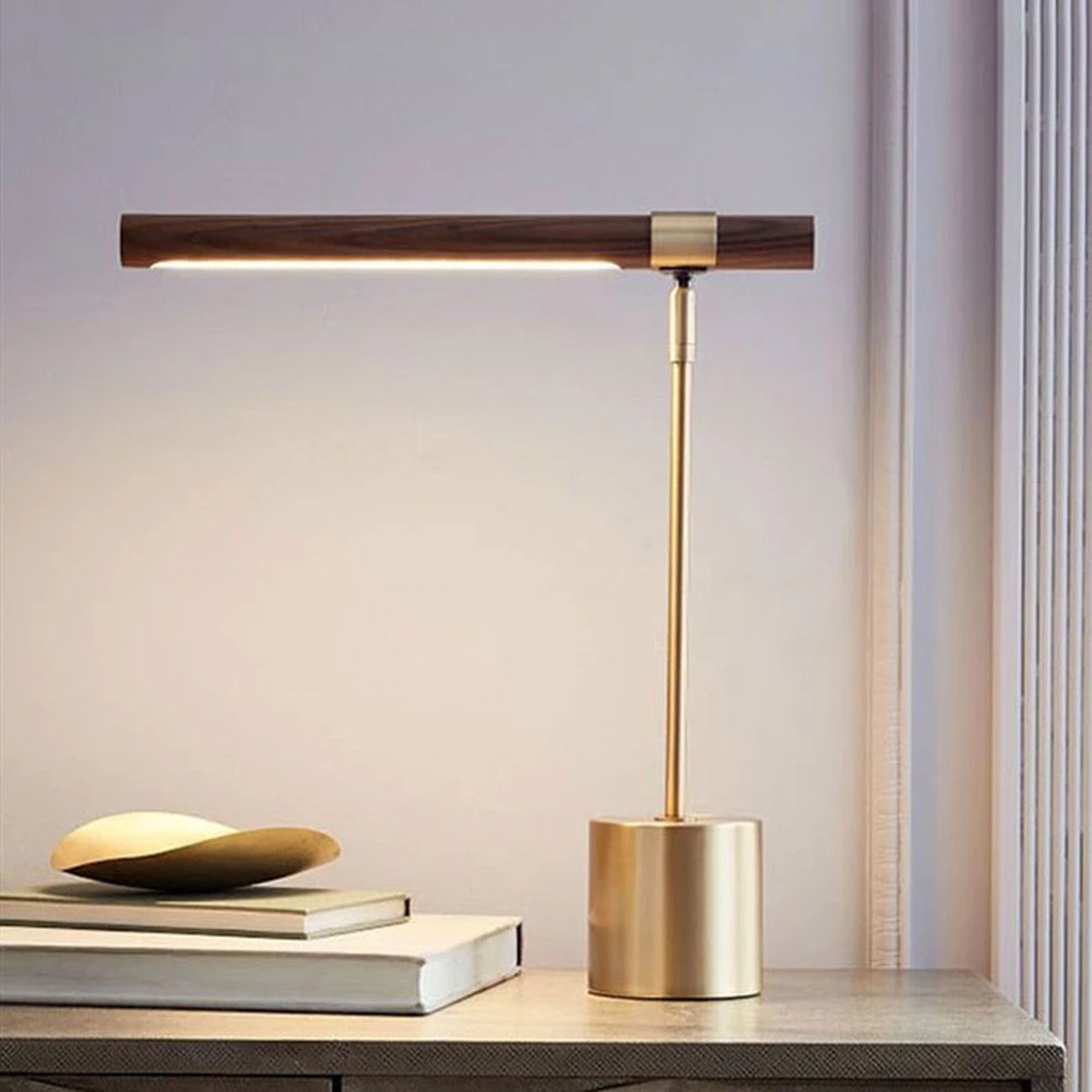 Lampe de bureau design Linéa allumée sur une console, ambiance chaleureuse en fin de journée.