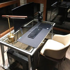 Lampe de bureau design Linéa éclairant un bureau le soir devant un écran.