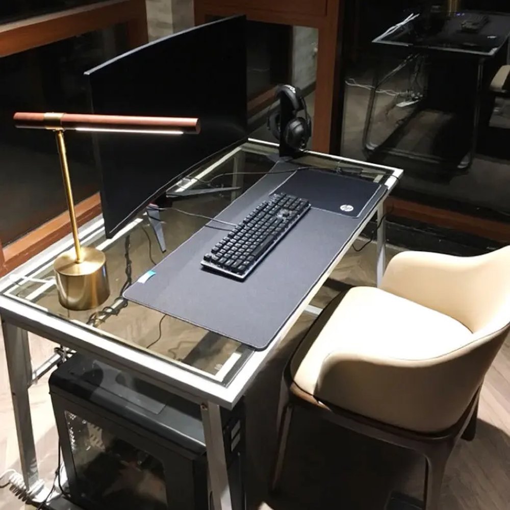 Lampe de bureau design Linéa éclairant un bureau le soir devant un écran.